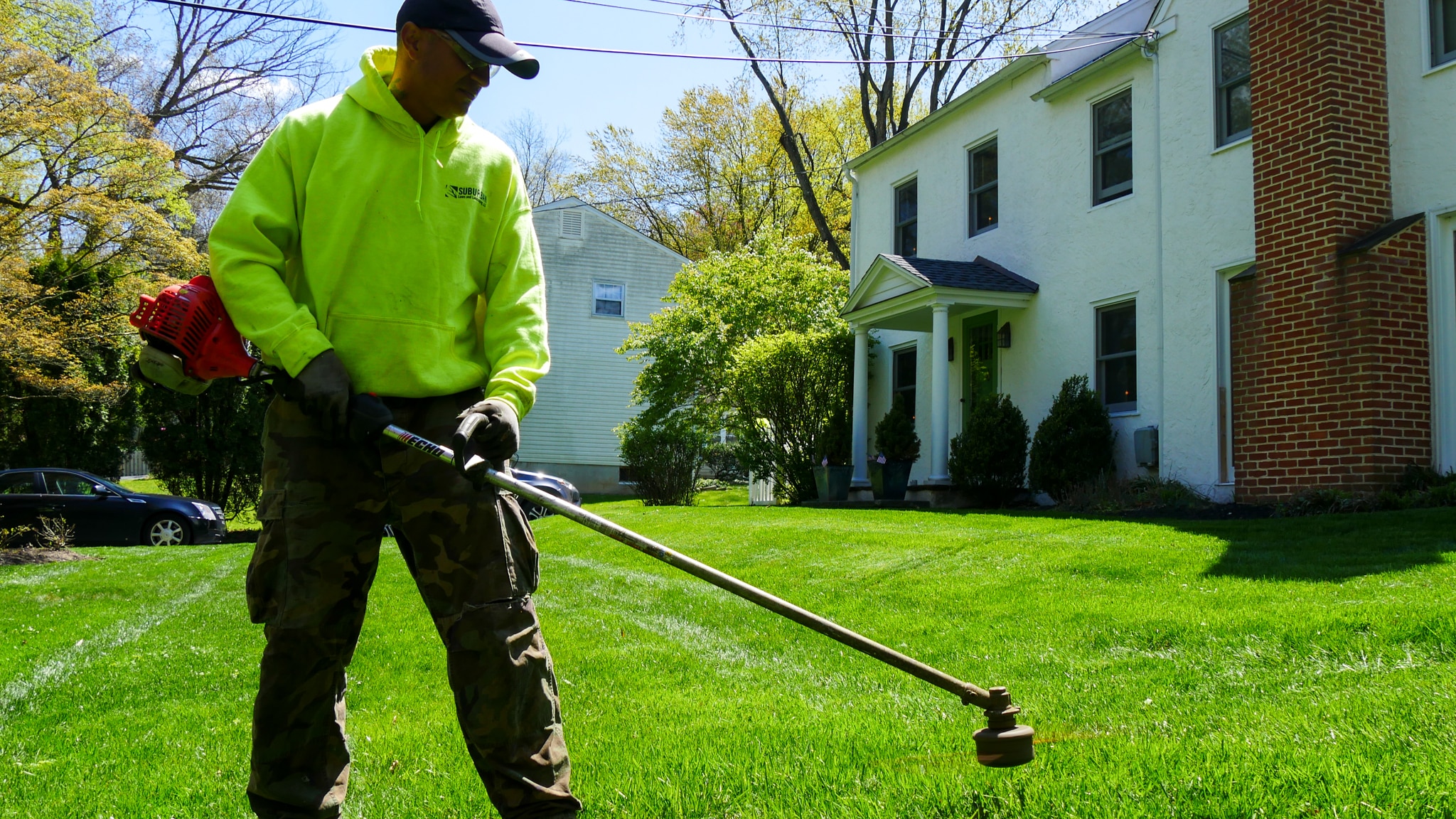 Worker using an edger in a residential lawn